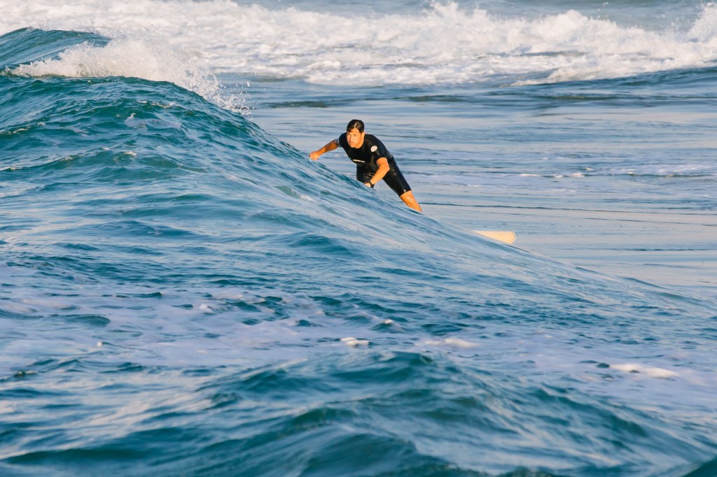 Surfer from Chania Surf Club in the waves in Platanias, Chania, Crete, Greece