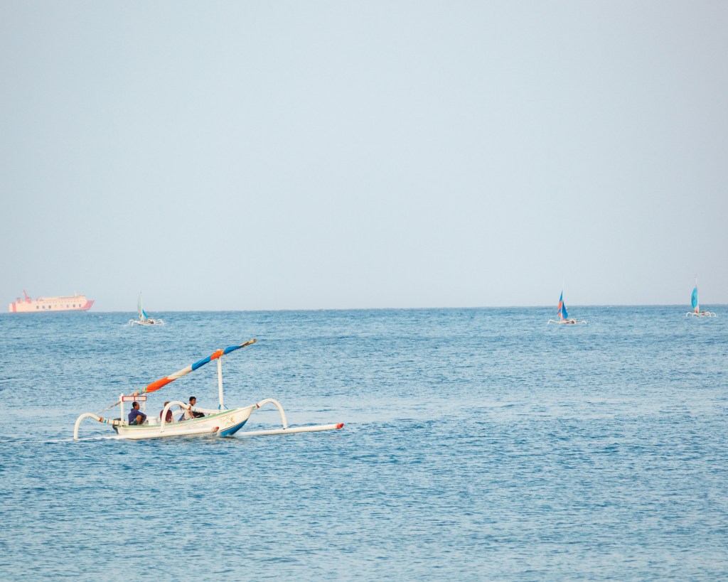 Fishing boat and ferry outside Lipah Beach in Amed, Bali, Indonesia