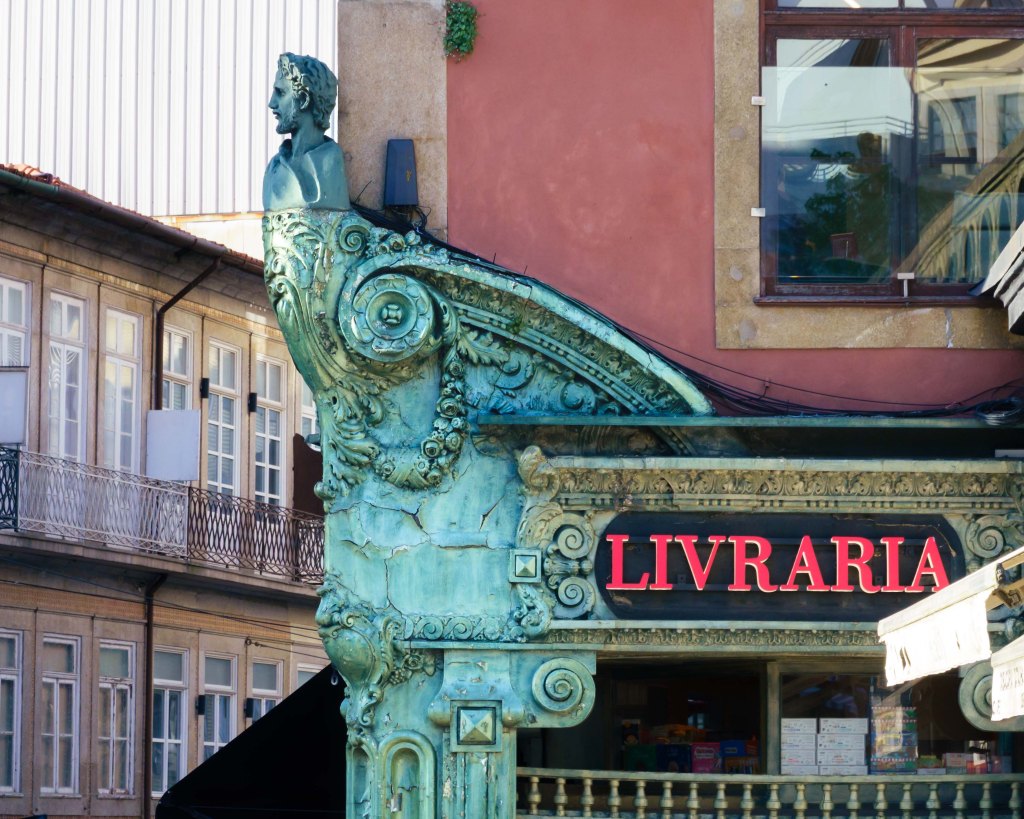 Statue on building of a book shop in Porto, Portugal