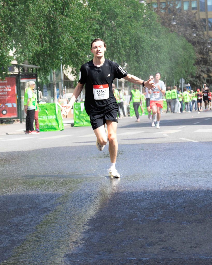 Runner enjoying the water along the track of Stockholm Marathon 2026