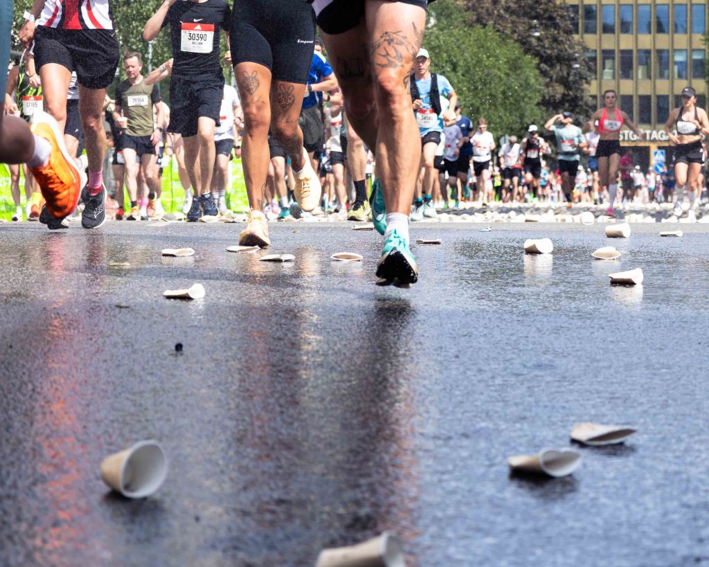 Paper cups and the feet of the runners at Adidas Stockholm Marathon 2026