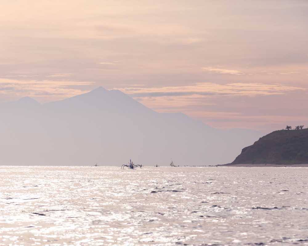 At sea with fishing boats and Mount Agung at the horizon, outside of Lombok, Indonesia,